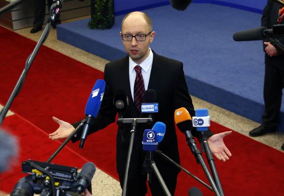 Ukraine's Prime Minister Yatsenyuk talks to reporters while leaving a European Union leaders summit in Brussels