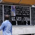 A man reads a board extolling China’s contribution to the fight against Ebola, in Monrovia