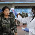 A Chinese military health worker has her temperature taken as she arrives at Roberts airport outside Monrovia, to help in the fight against Ebola