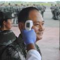 A Chinese military health worker has his temperature taken as he arrives at Roberts airport outside Monrovia, to help in the fight against Ebola