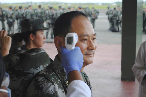 A Chinese military health worker has his temperature taken as he arrives at Roberts airport outside Monrovia, to help in the fight against Ebola