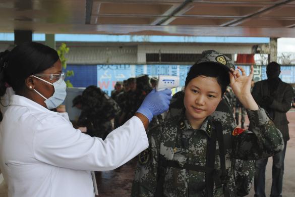 A Chinese military health worker has her temperature taken as she arrives at Roberts airport outside Monrovia, to help in the fight against Ebola