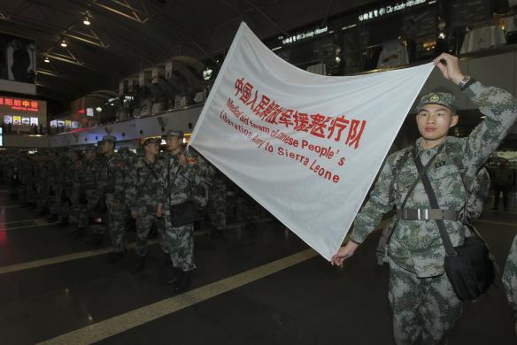 Members of a medical aid team of People's Liberation Army (PLA) carry a flag during their departure ceremony at Beijing Capital International Airport, in Beijing